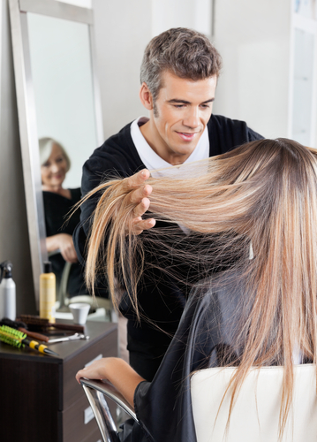 stock-photo-male-hairdresser-with-senior-female-client-selecting-color-from-catalogue-at-hair-salon-130534568